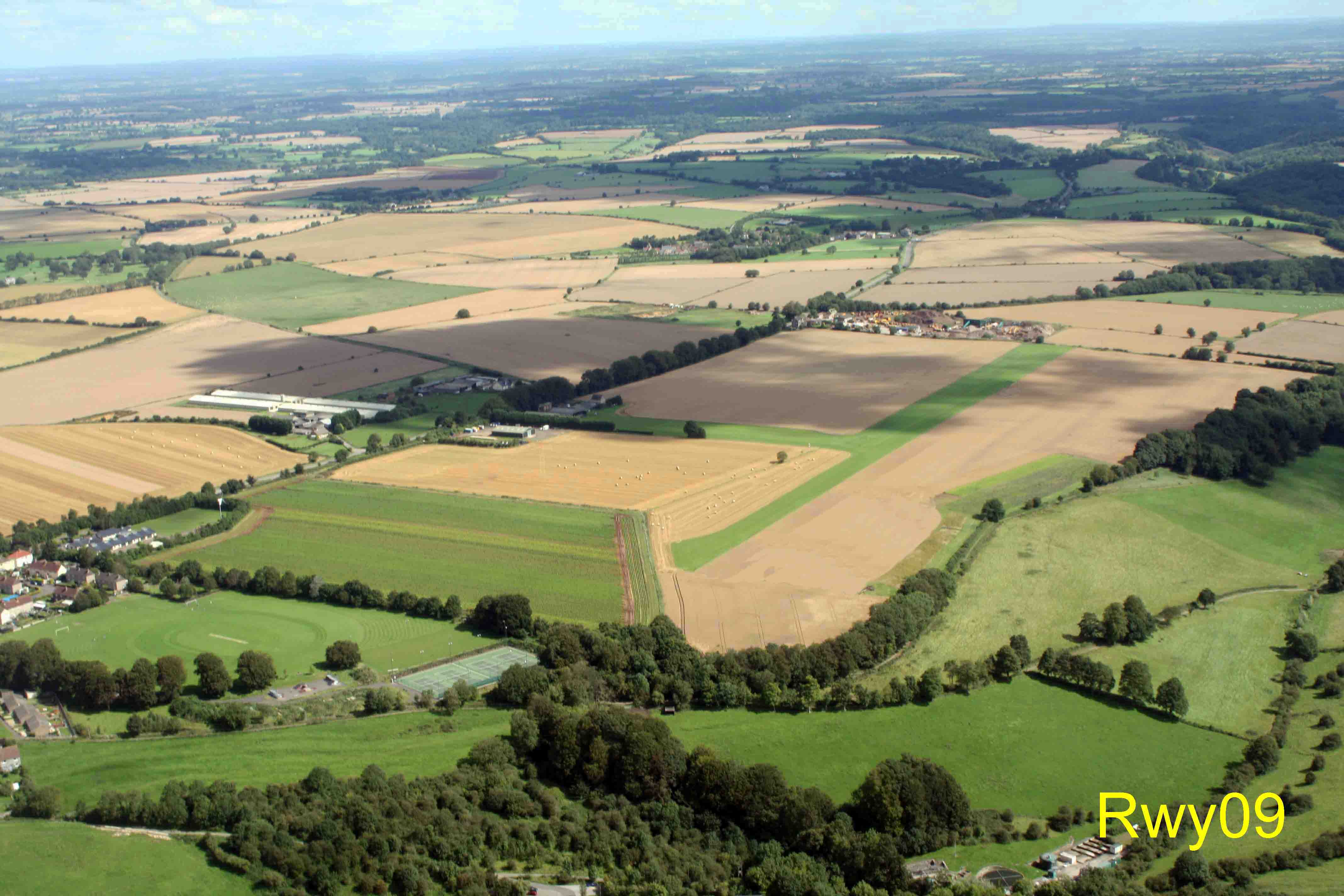 Garston Farm from the West. Rwy 09 approach through the gap between trees.  Marshfield village is bottom-left.